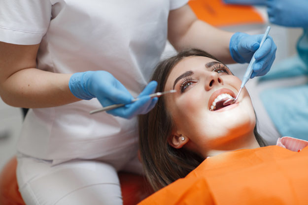 dental patient undergoing root canal retreatment while laying in dentist chair