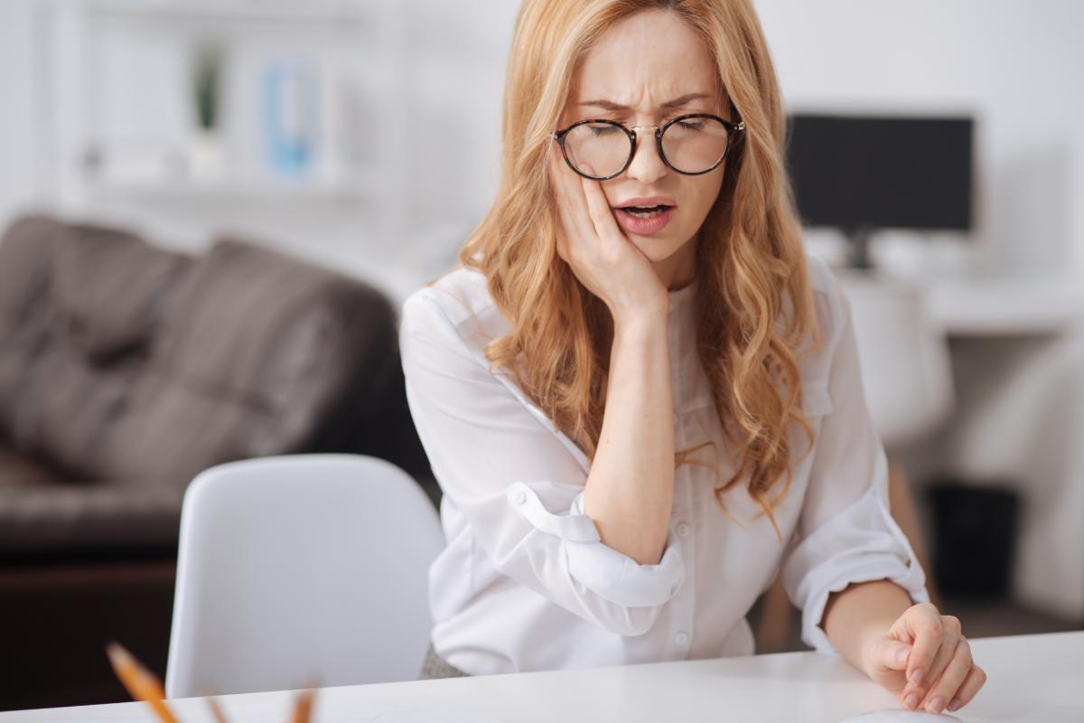 What to Do After a Traumatic Dental Injury a woman holding her mouth in pain, what to do after a traumatic dental injury