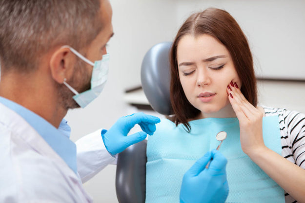 woman experiencing types of dental injuries