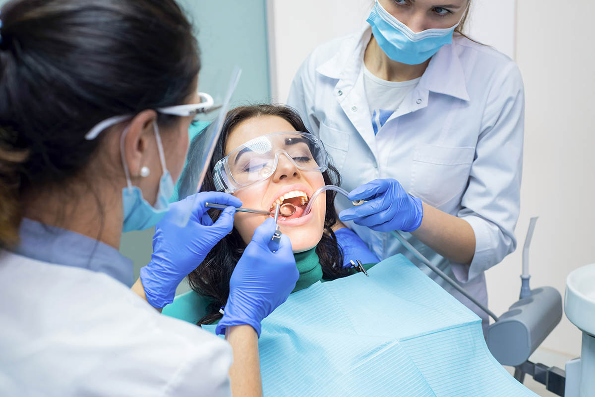 Are There Risks in Apicoectomy Procedures_ woman in dental chair learning about risks in apicoectomy procedures