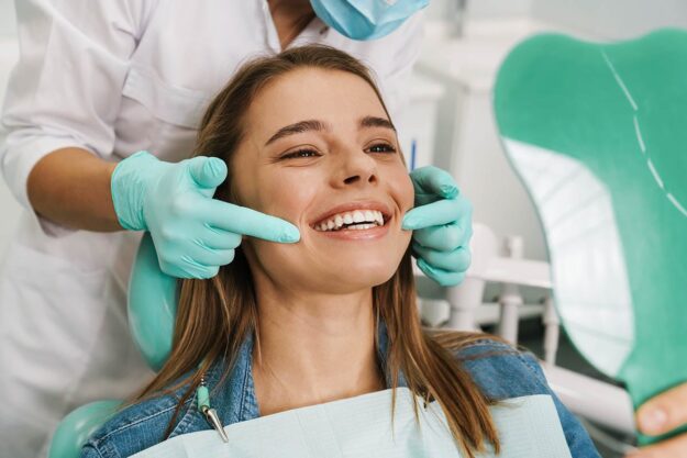 What Services Qualify as Endodontics woman smiles after receiving endodontics services