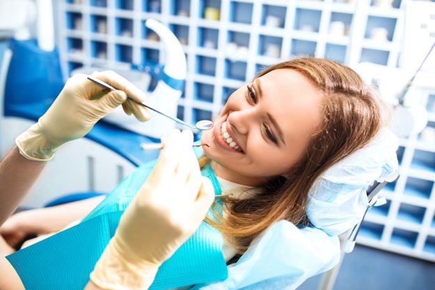 What are the steps of root canal therapy_ woman smiles at endodontist while receiving root canal therapy