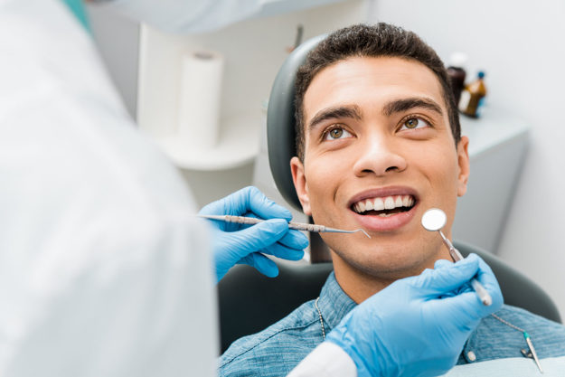 Why Choose Laser-Assisted Irrigation in Maryland_ man looks at endodontist as the endodontist performs laser-assisted irrigation in maryland