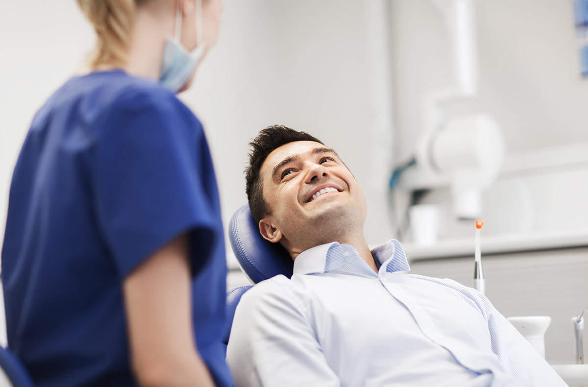 man smiles at dentist while discussing laser irrigation and disinfection benefits