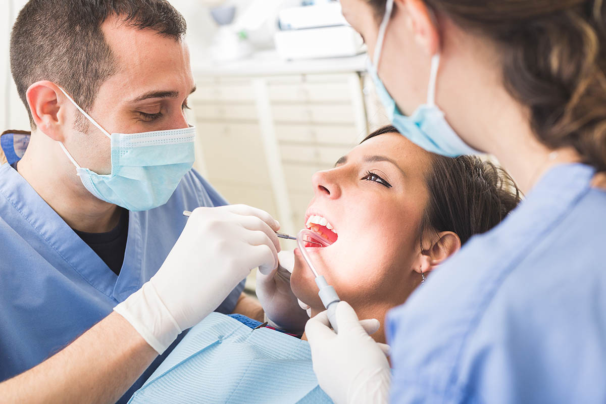 woman in dental chair talks to endodontist about what is dental trauma