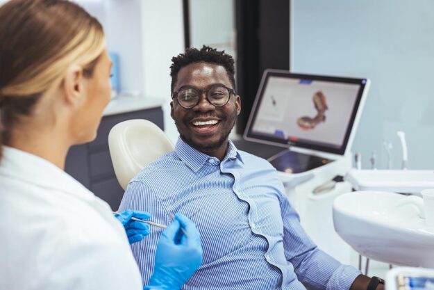 man smiles while talking with his endodontist about an apicoectomy in Maryland