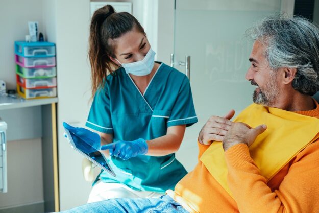 Dental professional talking to patient about apicoectomy cost