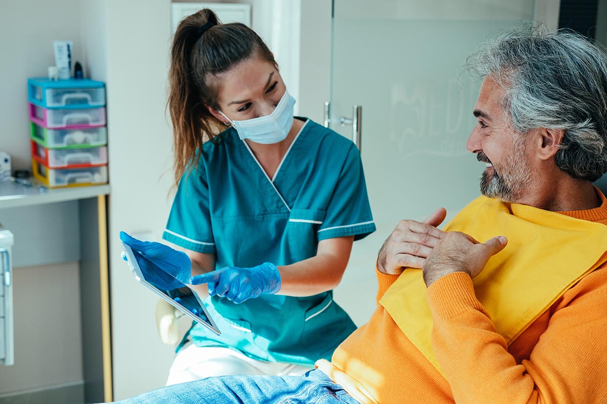 apicoectomy procedure Dental professional talking to patient about apicoectomy cost