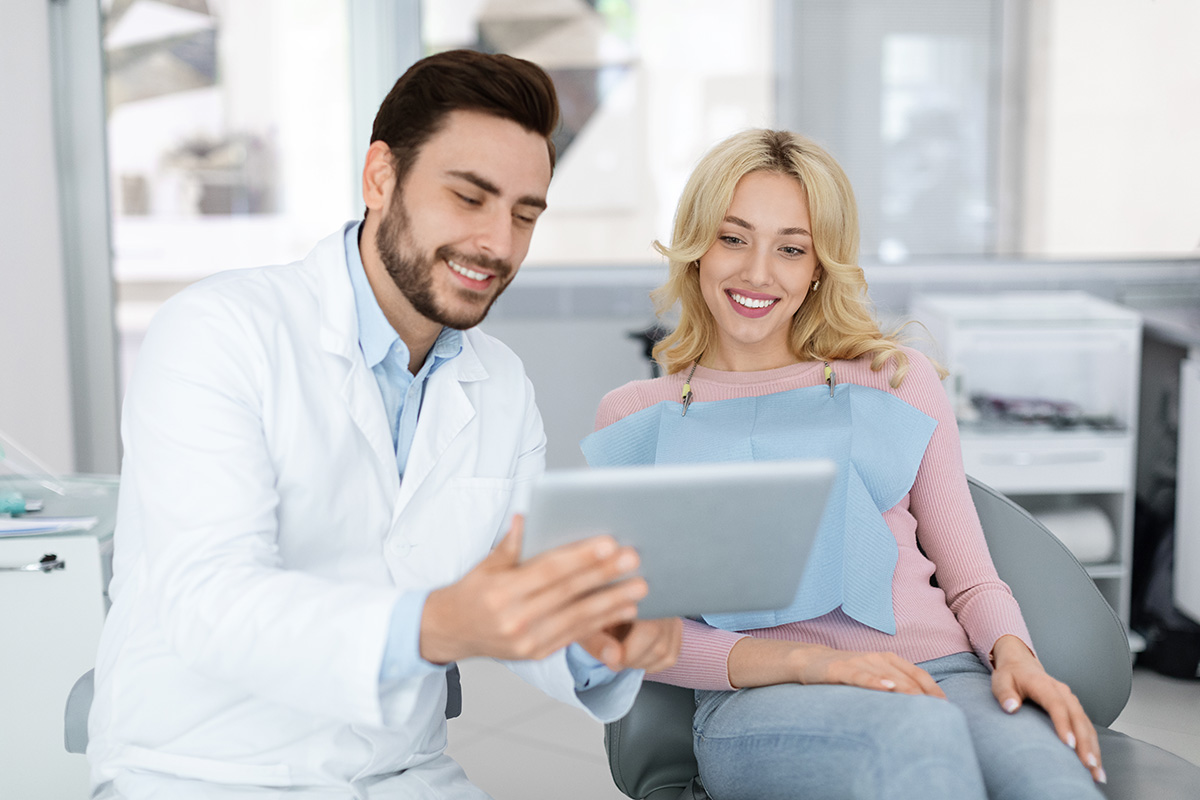 How an Apicoectomy Helps Treat Persistent Tooth Infections a dentist explains an apicoectomy procedure to a patient